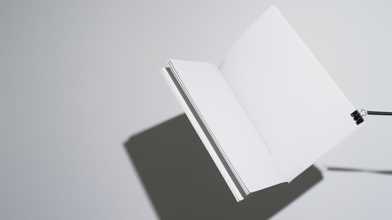 Video of hanging book with white blank pages and copy space on white background