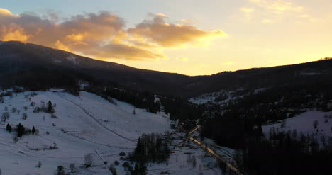 Vista-Aérea-De-Montañas-Y-Bosques-Cubiertos-De-Nieve-Al-Atardecer-En-Invierno-4