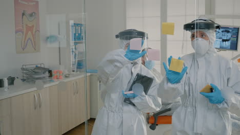 dentistry team of specialists using sticky notes on glass