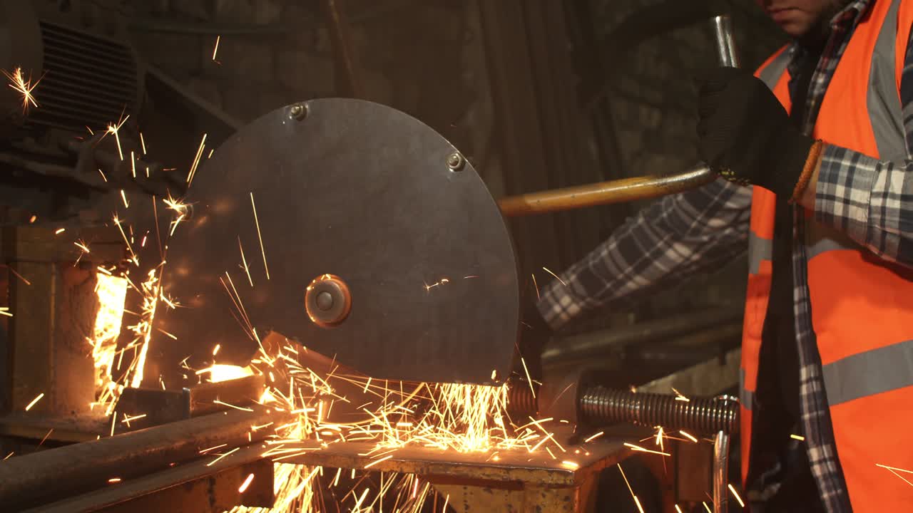 trabajador masculino cortando metal en un taller sucio