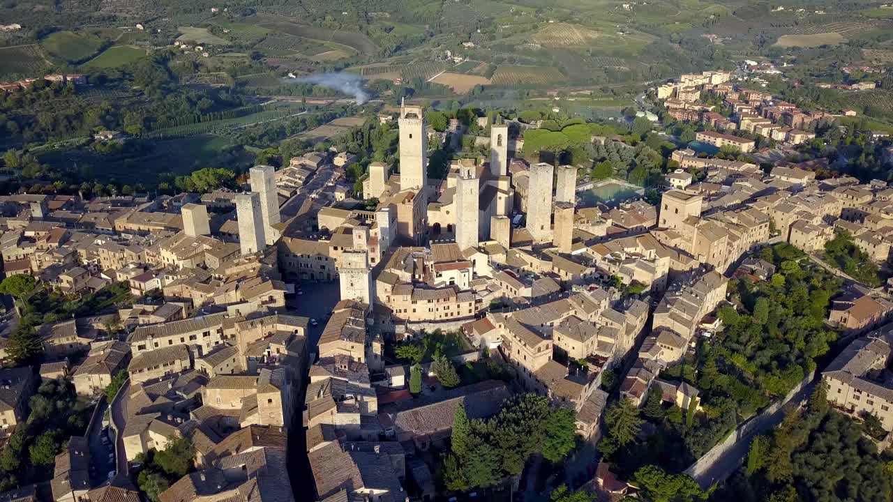 la ciudad italiana de san gimignano con la torre grossa y el centro de la basílica, toma aérea de círculo amplio