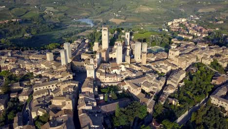 the italian town of san gimignano with torre grossa and basilica center, aerial wide circle shot