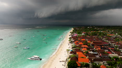 인도네시아 발리 주 누사 렘본간 (nusa lembongan) 의 해변을 따라 해안 마을을 가로질러 폭풍이 불면서 어두운 구름이