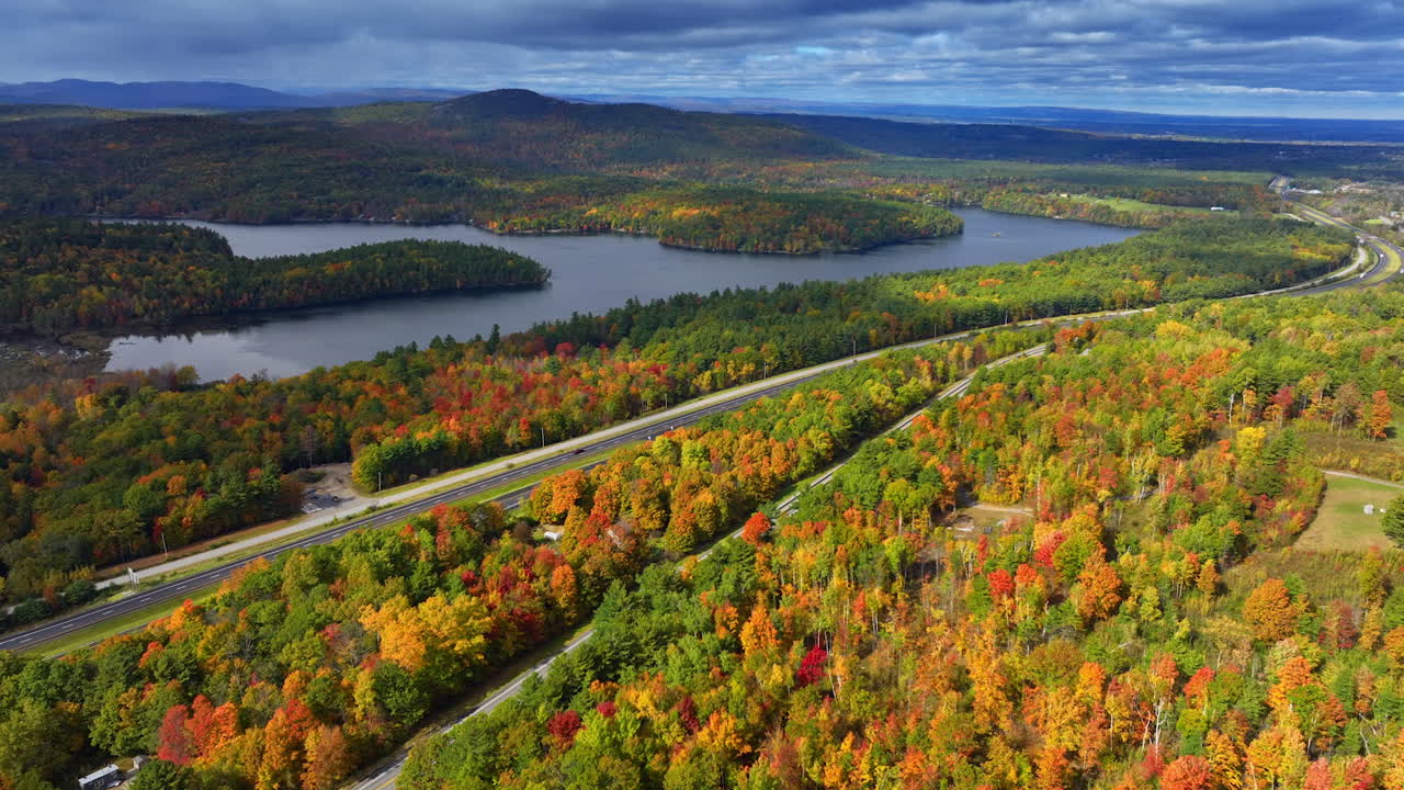 Vast colorful woods near the beautiful river. Overcast sky is above the scenery. Aerial view on the scenery.