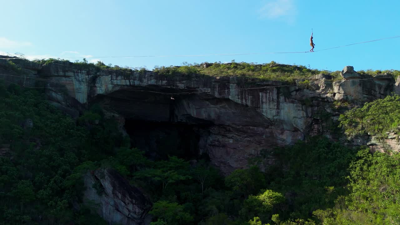 Aerial zoom-out two highliners walking two highlines Gruta do Lapão cave, Chapada Diamantina