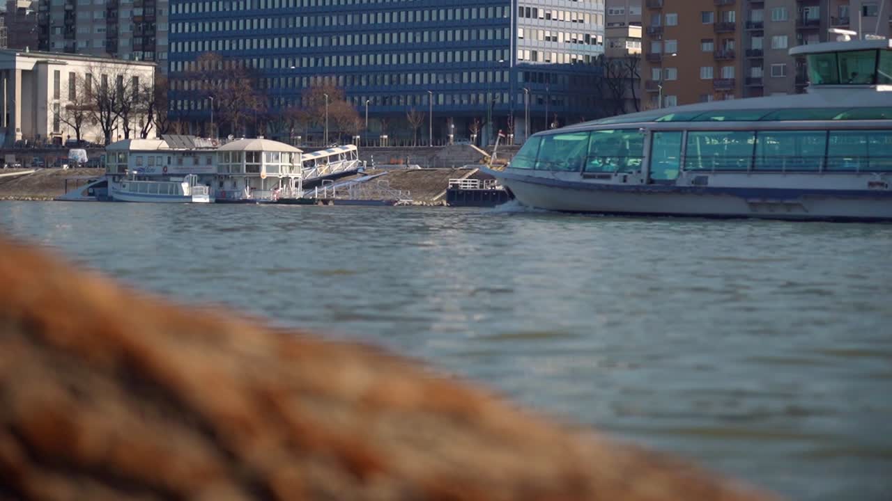 Modern tour boat docked near an urban riverbank