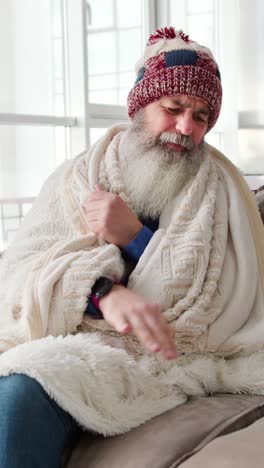 elderly man wrapped in blanket, possibly ill