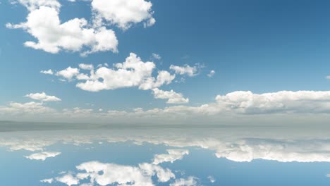 futuristic background consisting of time lapse clip of white fluffy clouds over blue sky and their reflection, video loop