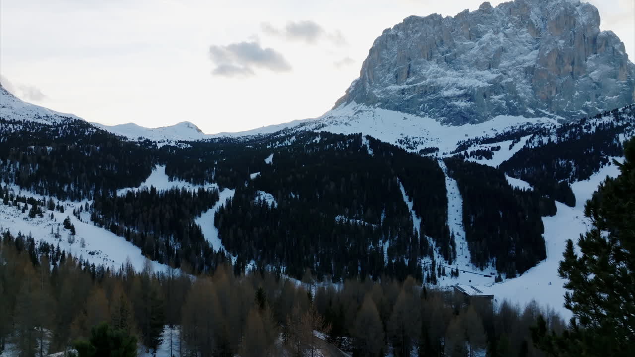 dolly aérea a la izquierda para revelar la vista sobre la nieve cubierta valle de val gardena en el norte de italia