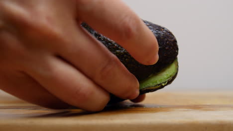 cutting open an avocado with a knife