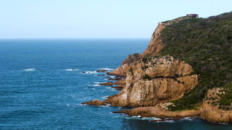 Cabeza-Oeste-Con-Un-Promontorio-Rocoso-Imponente-En-La-Desembocadura-Del-Río-Laguna-Knysna,-Las-Cabezas