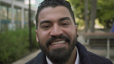 cheerful bearded man smiling at camera