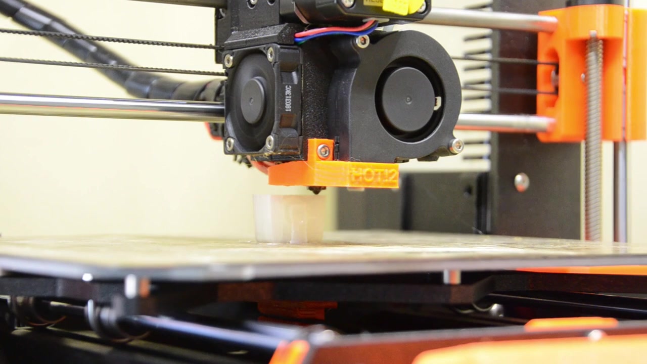 3D printer printing an items that shows the print bed and head moving