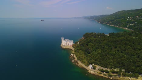 The-beautiful-Miramare-Castle,-standing-proudly-in-front-of-the-sea,-can-be-viewed-through-a-drone-camera