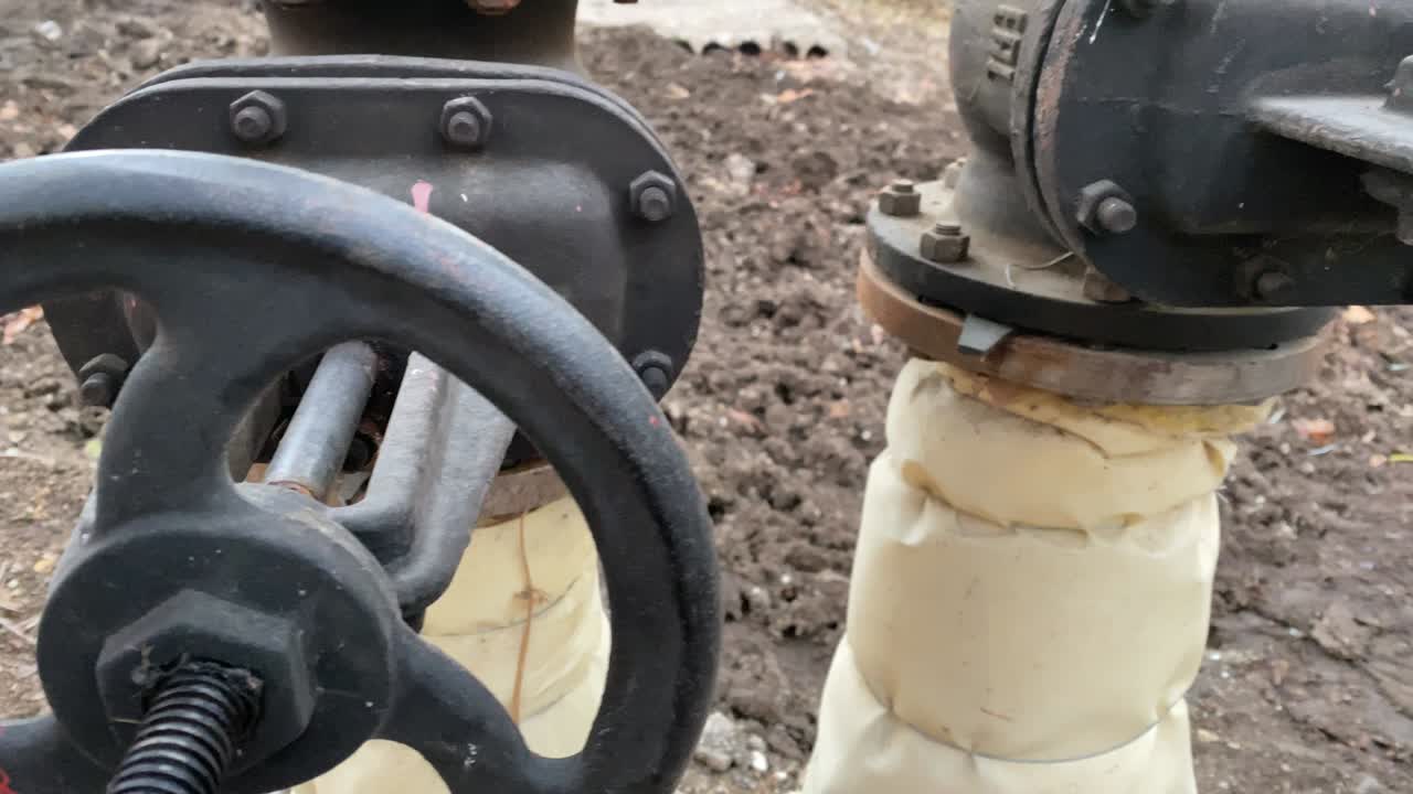 외부에 설치된 큰 브를 가진 금속 물 파이프.