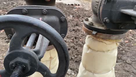 tubería de agua metálica con una válvula grande instalada en el exterior.