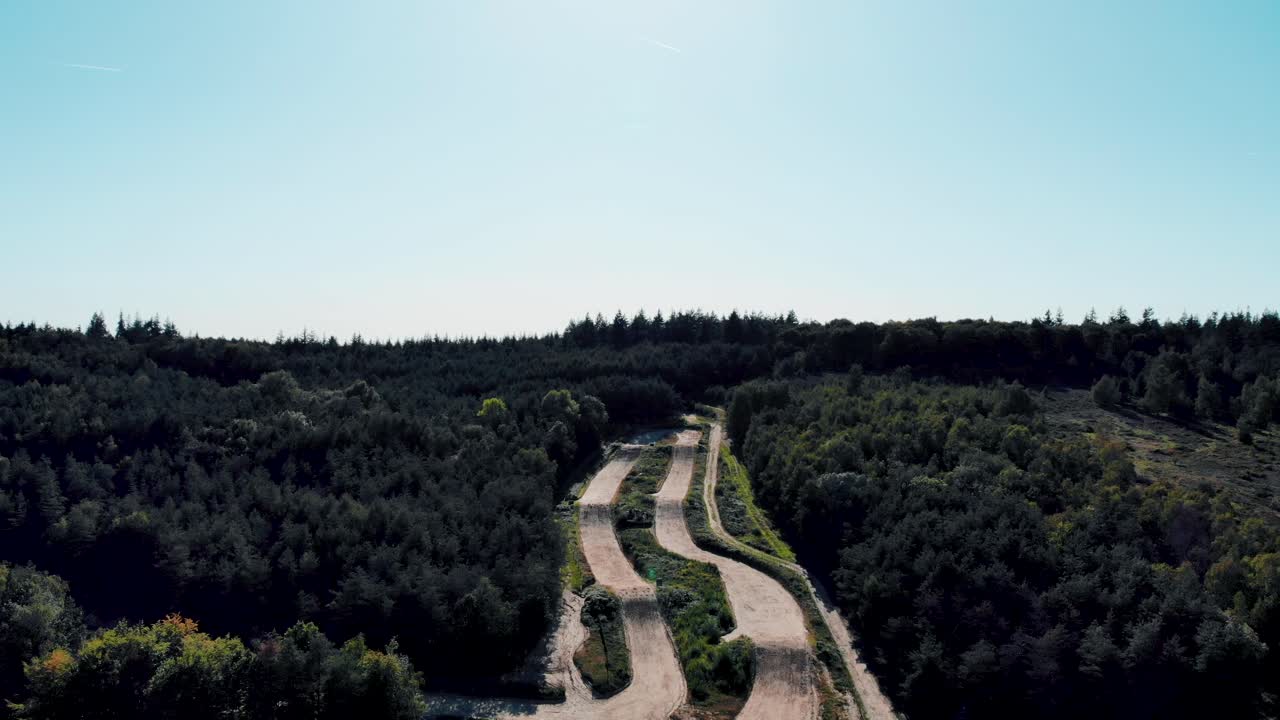 Aerial view overlooking woodland downhill freestyle cycling dirt freeride jumps in forest route