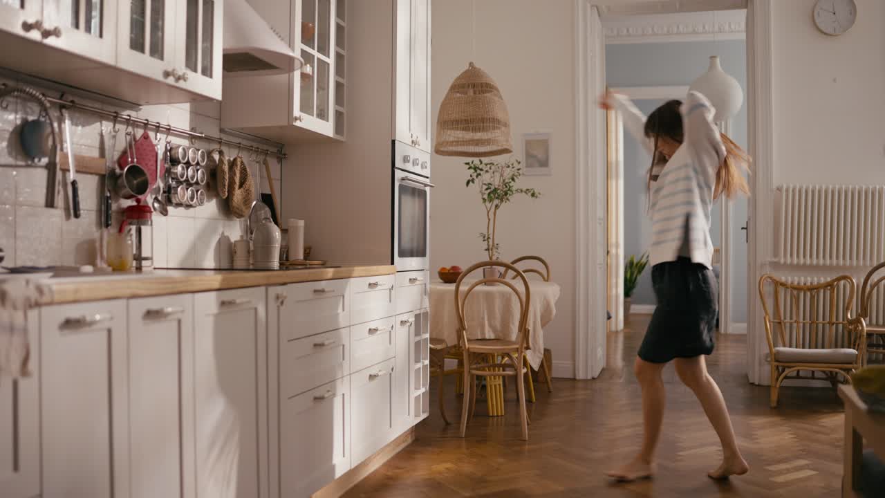 женщина танцует на кухне.