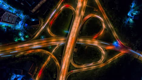 aerial drone high speed night video of urban elevated road junction and interchange overpass in city with light traffic.