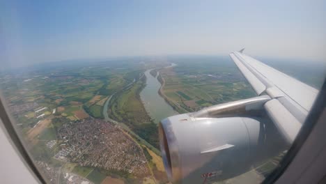 Airplane-windows-in-flight-turbine-in-closeup-Views-of-the-river-with-cultivated-fields
