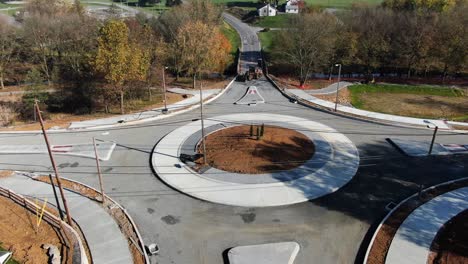 rising aerial tilt reveals traffic circle roundabout under construction, closed to cars and trucks