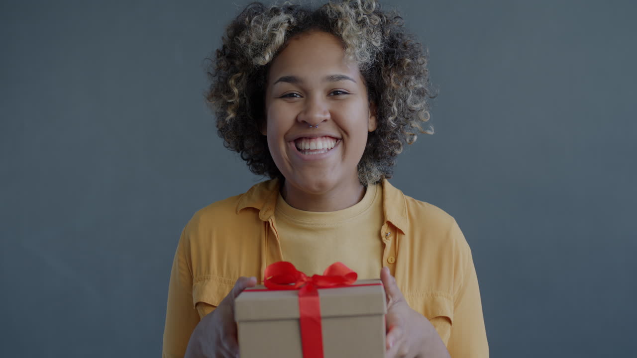 una mujer feliz recibiendo un regalo.