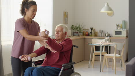 senior man in wheelchair exercising with dumbbells