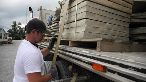 el camionero asegura su carga de piedra de construcción.