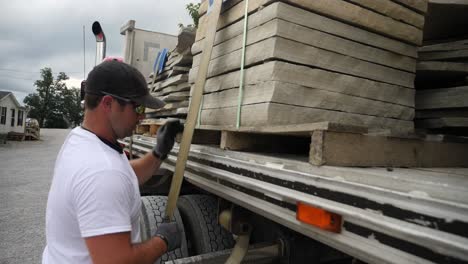 truck driver secures his load of building stone