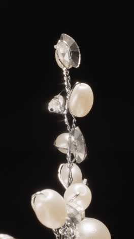 luxury hairpin shaped as twig with shiny gemstones at bright studio light. stylish expensive accessory for elegant hairstyles on black background macro