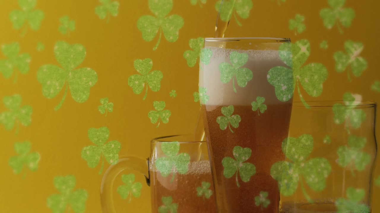 Animation of st patrick's day green shamrock falling over beer glasses