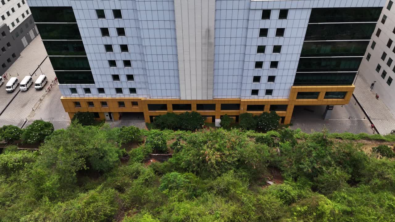 Urban Growth and Environment: Drone footage capturing a sprawling commercial center contrasting with a natural hillside