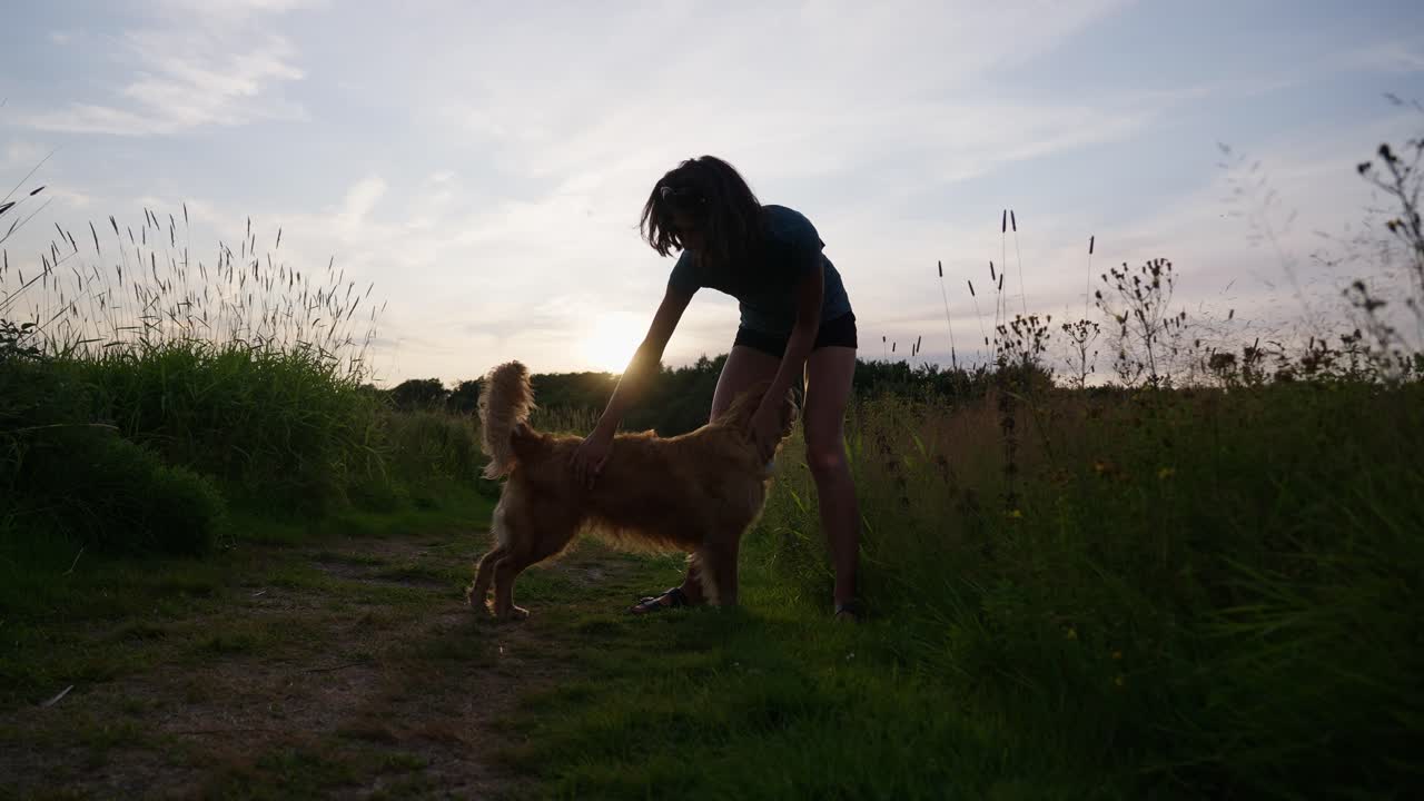 Enjoying a walk with a dog during sunset, capturing a joyful and peaceful moment