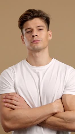a young man in a white t-shirt with arms crossed