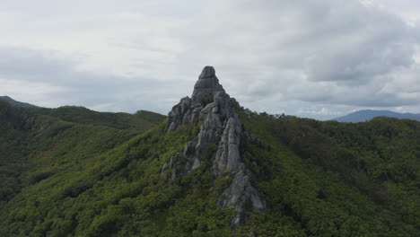 toma abierta de una enorme formación megalítica en la cima de una cordillera boscosa