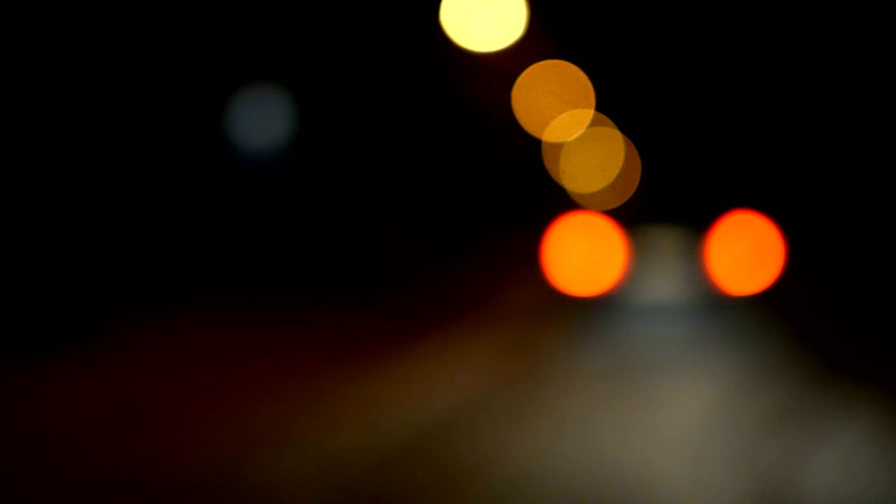 conducir un coche a través de la carretera de la noche, la autopista. luces desenfocadas calle de los ángeles resumen. ciudad fondo borroso. movimientos círculos bokeh de tráfico nocturno.