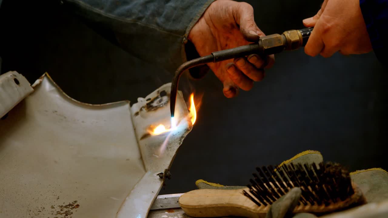 mecánico usando una antorcha en un coche parte 4k