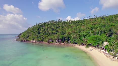 imágenes aéreas de drones de 4k toma de la órbita delantera de la playa de ensalada en koh phangan en tailandia con barcos de pesca, agua verde azulado, coral y selvas verdes