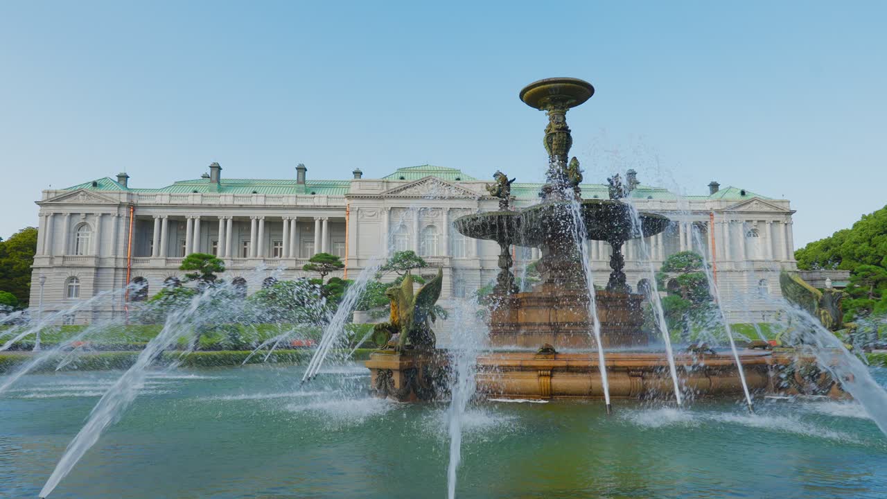 Vista simétrica y amplia de la elaborada fuente y la gran piscina con el gran Palacio Akasaka de estilo occidental detrás