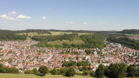 pullback and lock up aerial shot from a free meadow up to a comfortable community in the recreation area of the swabian alb, germany