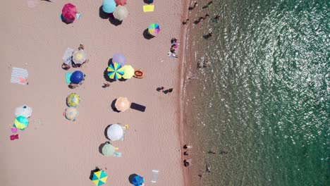 aerial top view shot of people on beach in sardinia coast during summer holidays in a sunny day