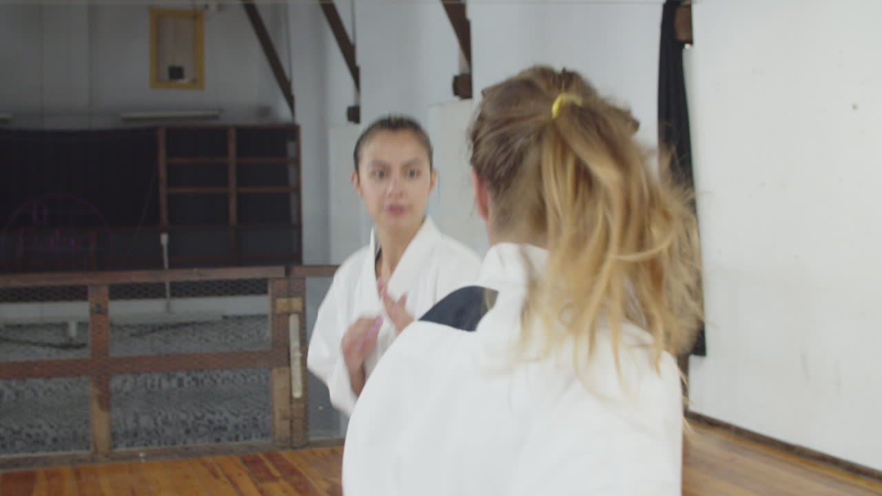 toma manual de niñas inclinándose antes de comenzar el entrenamiento de karate