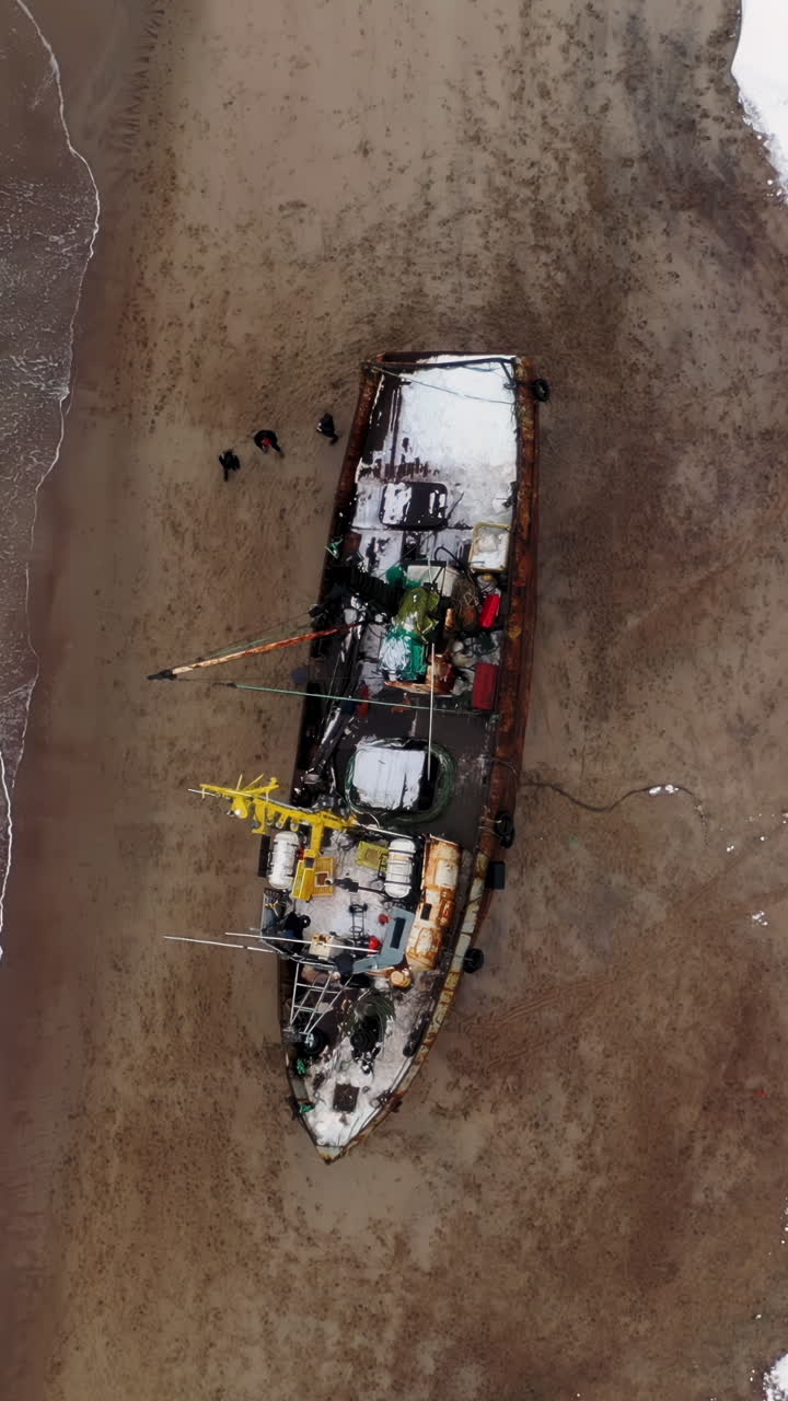 Barca da pesca abbandonata su una spiaggia invernale