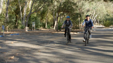 Senior-Couple-Cycling-Through-Park-In-Slow-Motion