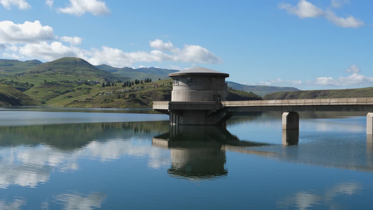 Water intake tower on calm picturesque hydro dam reservoir, blue sky