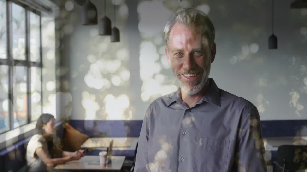 Animation of trees over smiling caucasian businessman