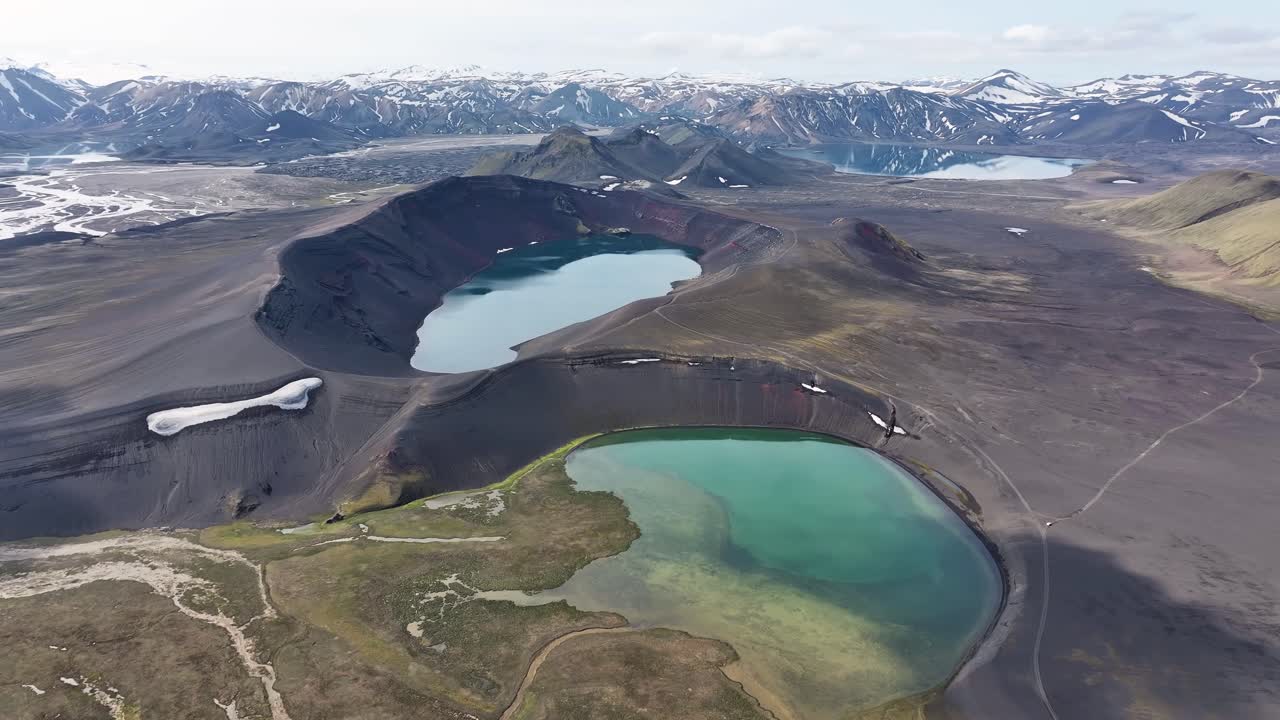 Witness the striking beauty of Iceland’s Ljótipollur crater lake from above, as deep red crater walls and vibrant blue water create a surreal volcanic landscape in the Icelandic highlands