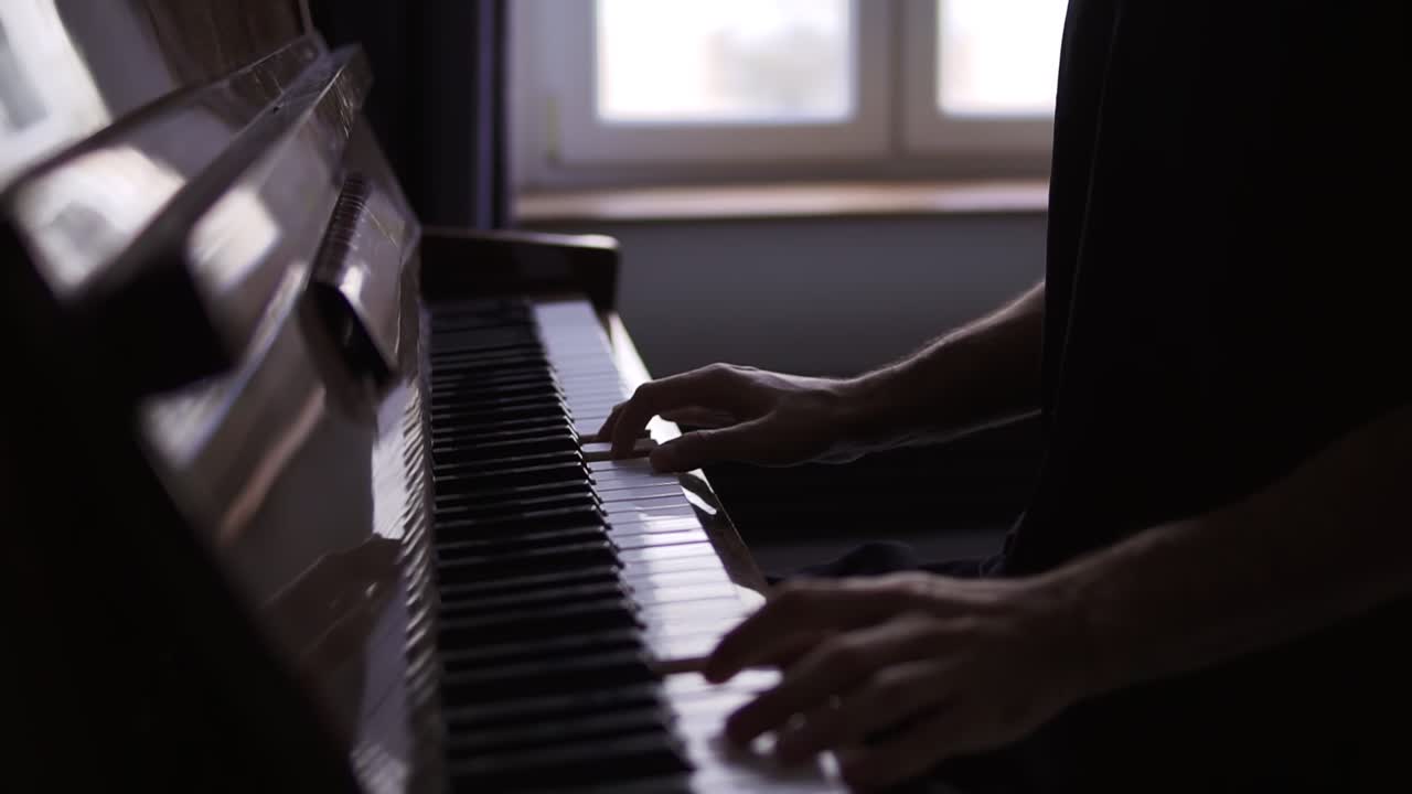 Closeup of male's hands practicing to play the piano at home