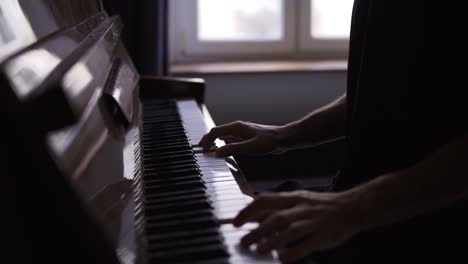 Primer-Plano-De-Las-Manos-De-Un-Hombre-Practicando-Tocar-El-Piano-En-Casa.