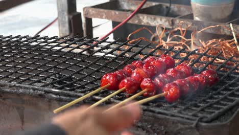 street food meatball skewers being grilled on the barbecue